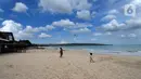 Anak-anak bermain layang-layang di kawasan Pantai Jimbaran, Bali, Jumat (3/9/2021). Sepinya wisatawan yang datang ke Pulau Bali selama PPKM Darurat yakni hanya sebesar rata-rata 500 wisatawan lokal menyebabkan sejumlah tempat wisata pantai sepi pengunjung. (merdeka.com/Arie Basuki)