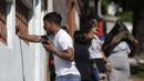 Seorang pria menangis ketika dia berbicara di telepon selulernya di luar Rumah Sakit Getulio Vargas di mana orang-orang menunggu kedatangan mereka yang terluka atau terbunuh dalam penggerebekan di favela Vila Cruzeiro di Rio de Janeiro, Brasil, Selasa (24/5/2022). (AP Photo/Bruna Prado)