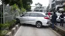 Sebuah mobil menabrak separator busway matraman arah kampung melayu, Jakarta, Sabtu (25/2). Diduga pengemudi kehilangan kendali yang akhirnya mengakibatkan menabrak separator busway. (Liputan6.com/Faizal Fanani)