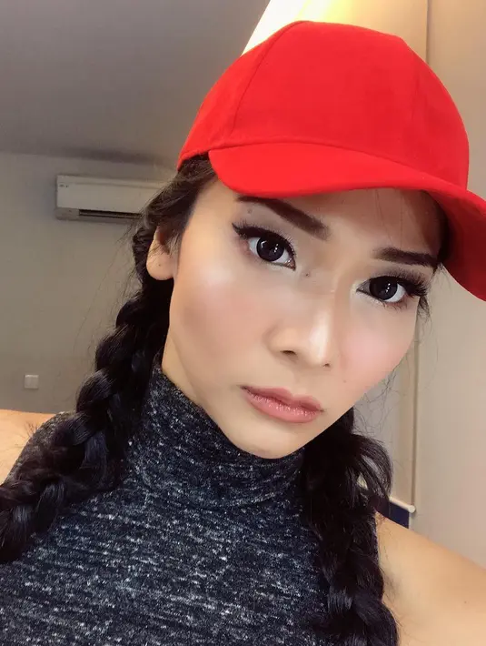 Nah, kali ini Mey Chan begitu unik dengan rambutnya yang dikepang dua dan topi berwarna merahnya. Makeup yang dipakainya juga begitu menawan dan tidak berlebihan. (Instagram/ditaofficial.id)