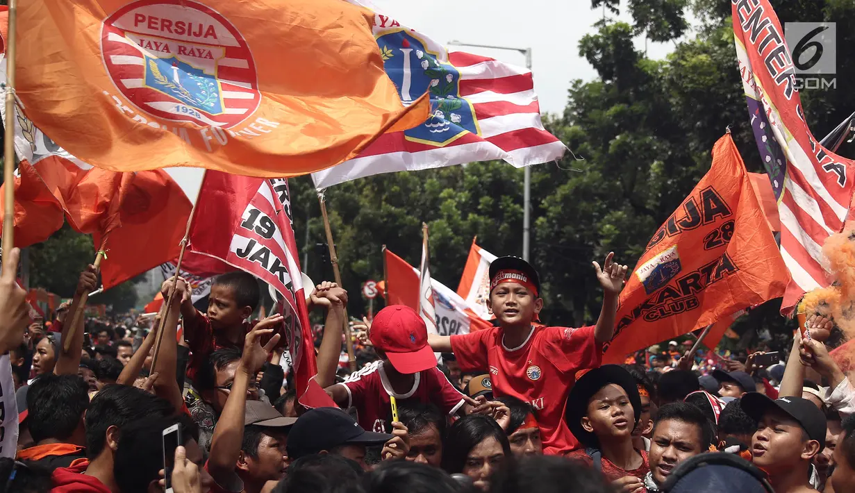 Jakmania merayakan kemenangan Persija saat penyerahan piala Liga I di depan Balai Kota, Jakarta, Sabtu (15/12). Kemenangan Persija di Liga 1 jadi momen bersejarah bagi masyarakat Ibu Kota. (Liputan6.com/Herman Zakharia)