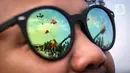 Refleksi gambar pada kacamata memperlihatkan layang-layang saat Festival Layang-Layang Jakarta di Pantai Lagoon Ancol, Jakarta, Kamis (22/6/2023). (Liputan6.com/Faizal Fanani)
