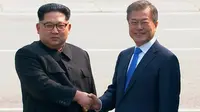 Pemimpin Korea Utara Kim Jong-un dan Presiden Korea Selatan Moon Jae-in berjabat tangan untuk memulai pertemuan bersejarah mereka di atas garis demarkasi Zona Demiliterisasi (DMZ), Panmunjom, Jumat (27/4). (Korea Broadcasting System via AP)