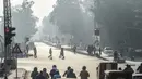 Orang-orang menyeberang jalan di tengah kondisi kabut asap di Lahore, Pakistan (23/11/2021). Kondisi kabut asap yang memburuk membuat Lembaga pendidikan, kantor swasta tutup selama tiga hari seminggu di Lahore. (AFP/Arif Ali)