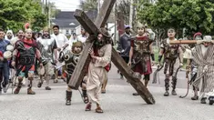 Anggota Gereja Katolik St. Joseph dan Paul berjalan menyusuri Seventh Street saat Live Way of the Cross atau pemeragaan kembali perjalanan Yesus menuju penyaliban-Nya pada peringatan Jumat Agung di Owensboro, Kentucky, Amerika Serikat, 15 April 2022. (Greg Eans/The Messenger-Inquirer via AP)