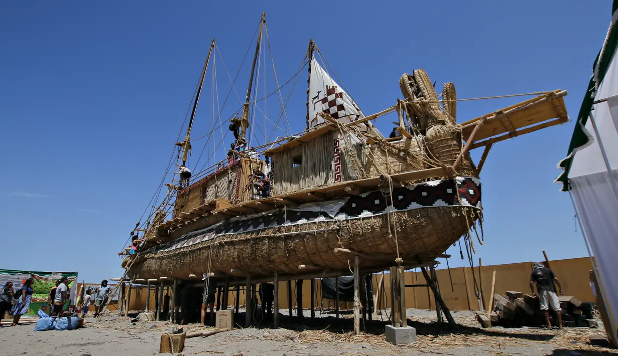 Sejumlah orang melihat dan menaiki perahu Viracocha III yang sedang bersandar di Pantai Chinchorro di kota Arica, Chili (5/2). Perahu unik yang terbuat dari rumput totora merupakan perahu tradisional Suku Aymara di Bolivia. (AFP Photo/Ignacio Munoz)