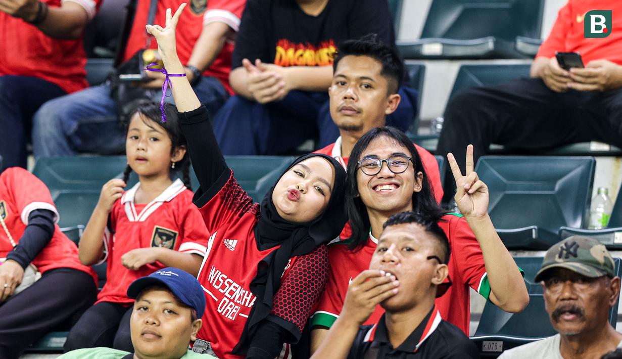 Ditemani rekan prianya, seorang suporter wanita berpose mendukung Timnas Indonesia U-17 saat menghadapi Timnas Panama U-17 pada laga kedua Grup A Piala Dunia U-17 2023 di Stadion Gelora Bung Tomo, Surabaya, Senin (13/11/2023). (Bola.com/Bagaskara Lazuardi)