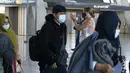 Keluarga dievakuasi dari Kabul, Afghanistan, berjalan melalui terminal sebelum naik bus setelah mereka tiba di Bandara Internasional Washington Dulles, di Chantilly, Va, Rabu (25/8/2021). (AP Photo/Jose Luis Magana)