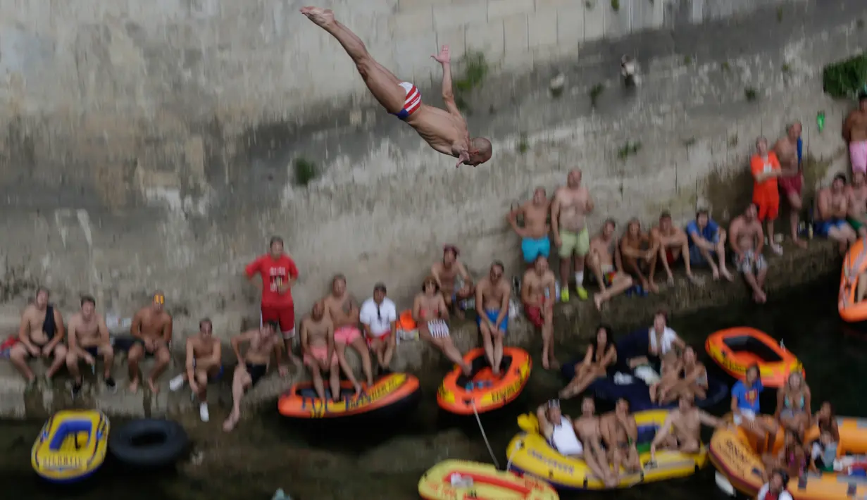 Penonton menyaksikan seorang peserta melompat dari Jembatan Old Mostar pada kompetisi menyelam tradisional ke-452 di Mostar, Bosnia, 29 Juli 2018. Kontes ini  sukses menarik 40 peserta lokal dan internasional dan penonton beberapa ribu. (AP/Amel Emric)