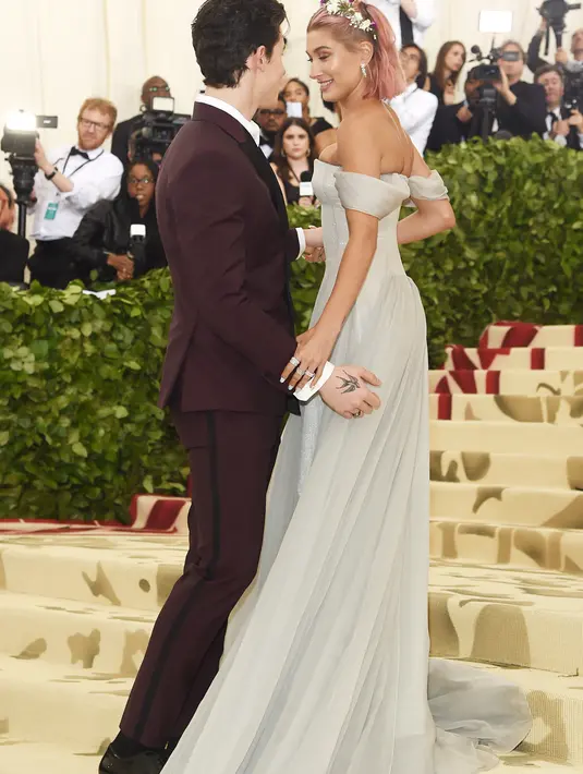 Hailey Baldwin pun memamerkan rambutnya yang berwarna pink dengan hiasan rambut bunga dalam Met Gala. (JAMIE MCCARTHY / GETTY IMAGES NORTH AMERICA / AFP)