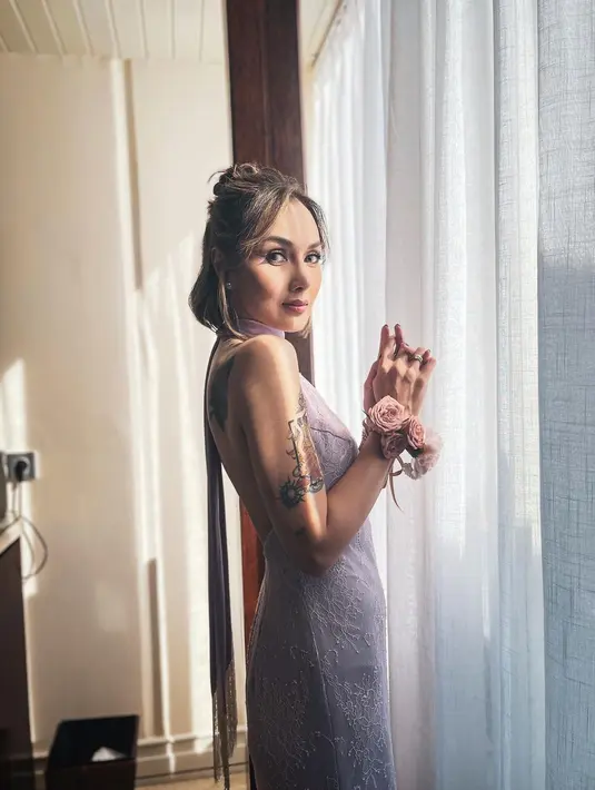 Dengan gaun bernuansa ungu, potongan halter neck dan backless sukses mengekspos tato di punggungnya. [@sarawijayanto]
