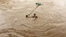 Anak-anak berenang di aliran Sungai Ciliwung yang meluap di Rawajati, Jakarta, Selasa (6/2). Meluapnya Sungai Ciliwung akibat intensitas hujan yang tinggi. (Liputan6.com/Immanuel Antonius)