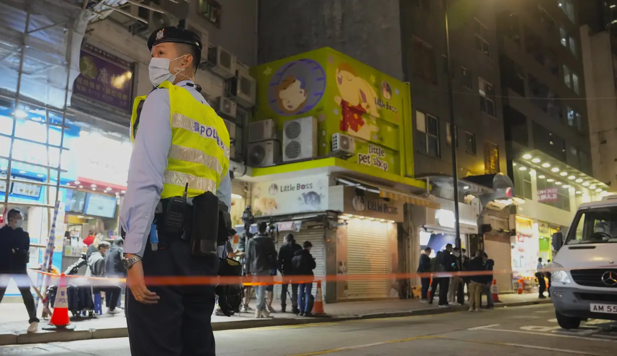 Polisi berjaga di luar toko hewan peliharaan yang ditutup setelah beberapa hamster dinyatakan positif corona di Hong Kong, Selasa (18/1/2022). Kasus Covid-19 di toko hewan peliharaan tersebut turut menginfeksi pegawai toko yang dikonfirmasi terjangkit varian Delta pada Senin (17/1).(AP Photo/Kin Che