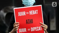 Peserta aksi dari Koalisi Masyarakat Sipil AntiKorupsi membawa poster saat berunjukrasa di depan Gedung KPK Jakarta, Selasa (18/5/2021). Dalam aksinya mereka memberi dukungan kepada 75 pegawai KPK yang dinyatakan tidak lulus TWK dalam tahap alih status kepegawaian. (Liputan6.com/Helmi Fithriansyah)