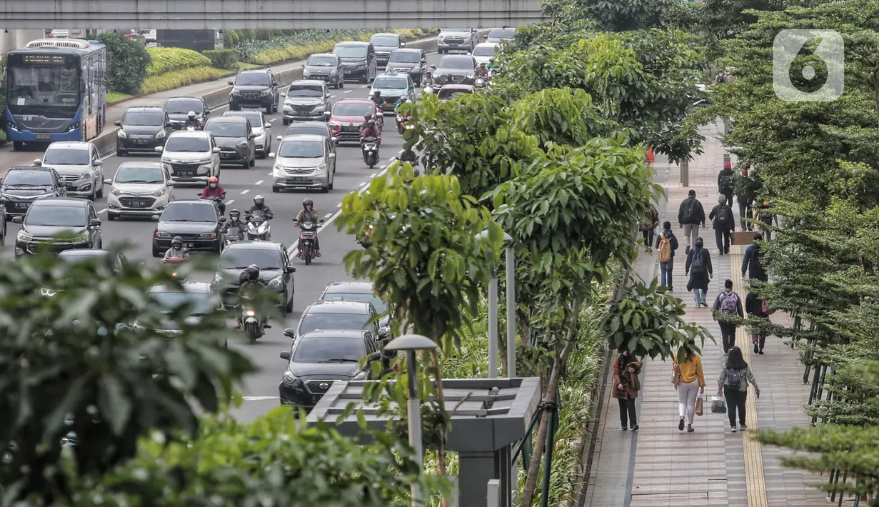 Pegawai pulang kerja berjalan di trotoar Jalan Sudirman, Jakarta, Selasa (12/5/2020). Pemerintah memberi kelonggaran bergerak bagi warga berusia di bawah 45 tahun untuk mengurangi angka pemutusan hubungan kerja (PHK) akibat pandemi virus corona COVID-19. (Liputan6.com/Johan Tallo)