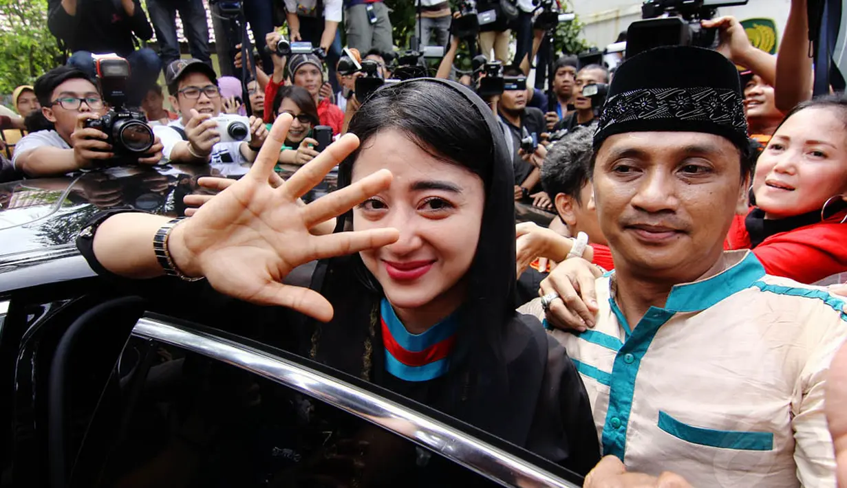 Sebelum masuk ke dalam mobil, Dewi Perssik melambaikan tangan pada media yang mengelilinginya dengan senyum menahan tangis, Rabu (14/05/14). (Liputan6.com/Faizal Fanani)