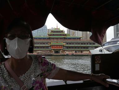 Seorang wanita menaiki perahu di Restoran Terapung Jumbo Hong Kong bergaya kekaisaran China di Hong Kong, Senin (13/6/2022). Restoran yang ditampilkan dalam banyak film lokal dan internasional selama bertahun-tahun ini terancam tutup di tengah biaya perawatan yang amat mahal setelah berbulan-bulan pembatasan COVID-19. (AP Photo/Kin Cheung)