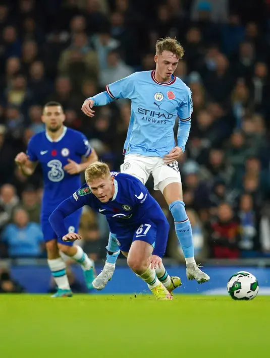 Pemain Manchester City Cole Palmer (atas) berebut bola dengan pemain Chelsea Lewis Hall pada pertandingan sepak bola putaran ketiga Piala Liga Inggris atau Carabao Cup di Etihad Stadium, Manchester, Inggris, 9 November 2022. Manchester City menang 2-0. (AP Photo/Dave Thompson)