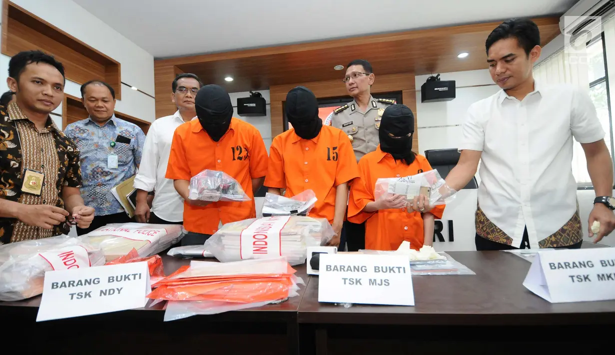 Petugas Ditpidsiber Polri menunjukkan tersangka barang bukti jaringan jual beli surat keterangan sakit online saat rilis di Jakarta, Jumat (12/1). Ditpidsiber Mabes Polri menangkap tiga tersangka berikut barang bukti. (Liputan6.com/Helmi Fithriansyah)