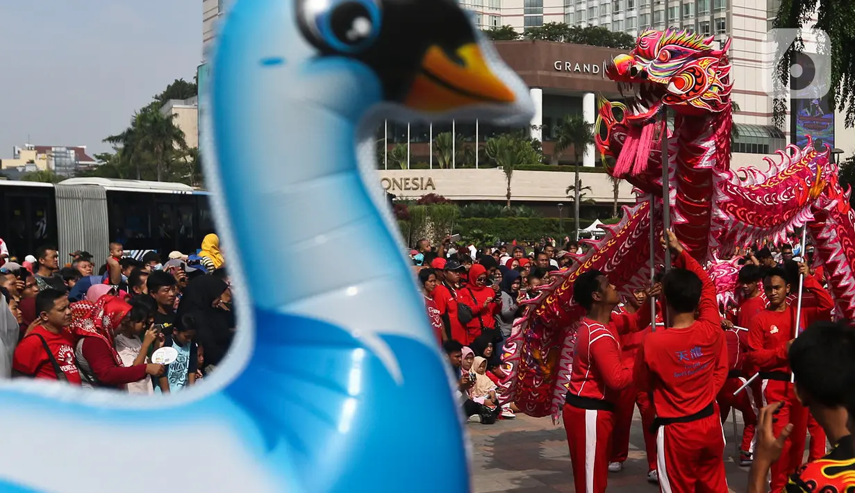 Penari memainkan tarian naga saat ajang car free day (CFD) di kawasan Bundaran HI Jakarta, Minggu (26/1/2020). Atraksi barongsai dan tarian nagatersebut sengaja dihadirkan dalam rangka perayaan Imlek 2020 untuk menghibur para warga yang tengah mengikuti CFD. (Liputan6.com/Johan Tallo)