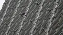 Alain Robert yang dijuluki 'French Spiderman' memanjat gedung pencakar langit Cheung Kong Center di Hong Kong, Jumat (16/8/2019). Alain Robert membentangkan spanduk perdamaian ketika pusat bisnis tersebut mengalami masalah internal dan maraknya demonstrasi. (AP Photo/Vincent Thian)
