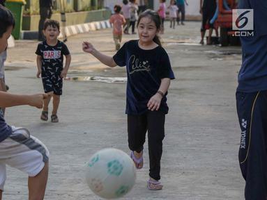 Anak-anak pencari suaka bermain sepak bola di halaman bekas Markas Kodim di Kalideres, Jakarta, Selasa (16/7/2019). Sebelumnya, para pencari suaka dari berbagai negara berkonfilk ini tinggal di pinggir jalan dan trotoar di kawasan Kebon Sirih, Jakarta. (Liputan6.com/Helmi Fithriansyah)