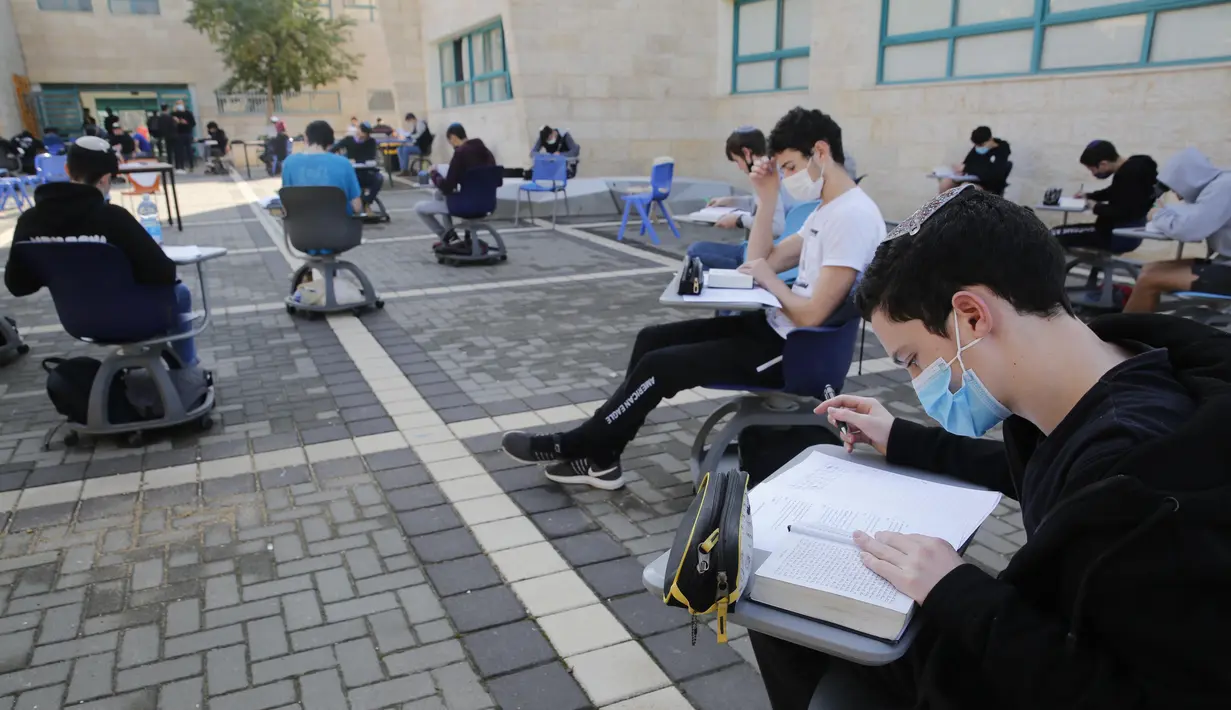 Para murid sekolah menengah atas (SMA) belajar di area luar ruangan sebuah sekolah di Kota Modiin, Israel pada  29 November 2020. Israel memulai kembali kegiatan pembelajaran tatap muka untuk SMA di kota besar dan kecil yang dikategorikan sebagai zona "hijau" atau "kuning". (Xinhua/Gil Cohen Magen)