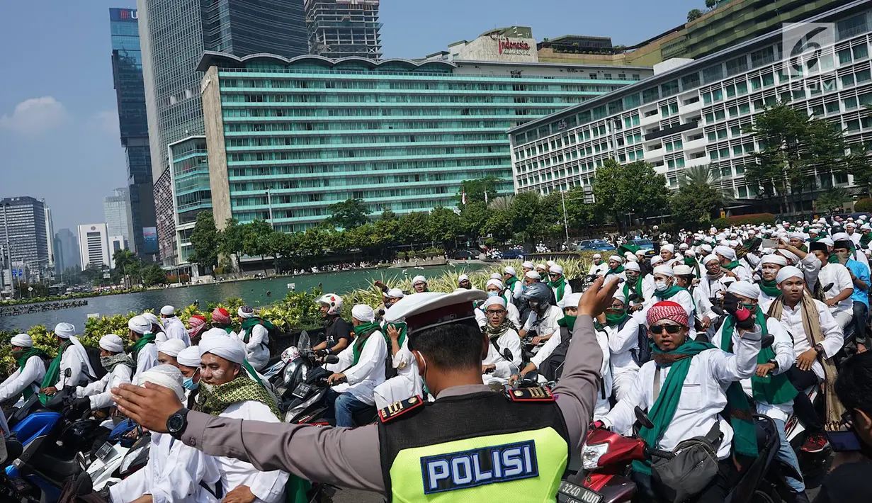Anggota kepolisian mengatur arus lalu lintas saat rombongan bermotor dari laskar Front Pembela Islam (FPI)  melintas di kawasan Bundaran HI, Jakarta, Rabu (22/5/2019). Massa aksi 22 Mei akan mulai memadati sekitar Bawaslu selepas Dzuhur. (Liputan6.com/Immanuel Antonius)