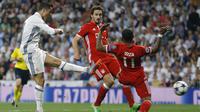 Cristiano Ronaldo melakukan tembakan mematikan melewati adangan para pemain Bayern Munchen pada leg kedua perempatfinal Liga Champions di Santiago Bernabeu stadium, Madrid, (18/4/2017). Ronaldo cetak tiga gol. (AP/Francisco Seco)