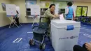 Seorang wanita memasukkan surat suara di sebuah TPS di Seoul, Korea Selatan (Korsel), Selasa (9/5). Warga Korsel menggunakan hak suaranya untuk memilih presiden baru setelah pemakzulan Park Geun-hye yang dijerat skandal korupsi. (AP Photo/Ahn Young-joon)