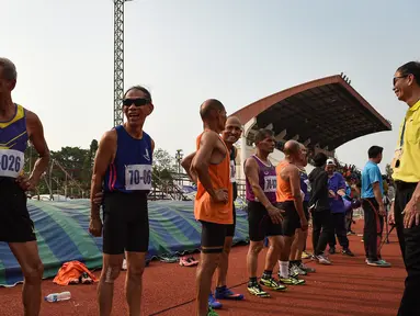 Sejumlah pria lansia bersiap mengikuti lomba sprint 400 meter dalam Elderly Games nasional di Thailand (25/4). Peserta lomba lari 400 meter ini merupakan lansia yang berusia antara 70-75 tahun. (AFP/Lillian Suwanrumpha)