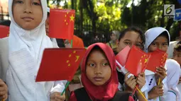 Sejumlah murid menyambut kedatangan PM China Li Keqiang di kawasan Istana Bogor, Senin (7/5). Li akan melakukan pertemuan bilateral dengan Presiden Jokowi membahas proyek pembangunan jaringan kereta api cepat Jakarta-Bandung.  (Merdeka.com/Arie Basuki)