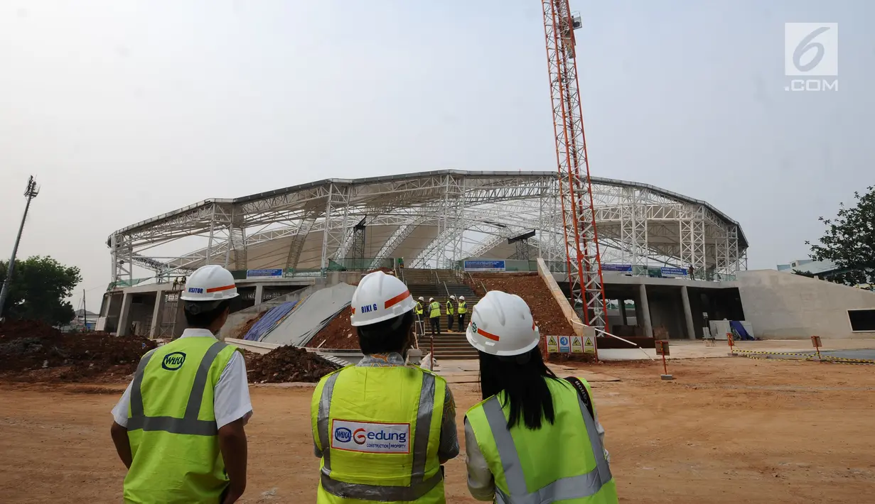 Pekerja melihat progres pembangunan stadion balap sepeda atau velodrom di Rawamangun, Jakarta, Jumat (3/11). Pembangunan velodrom bertaraf internasional ini sudah mencapai 68 persen dan ditarget selesai, Juni 2018. (Liputan6.com/Helmi Fithriansyah)