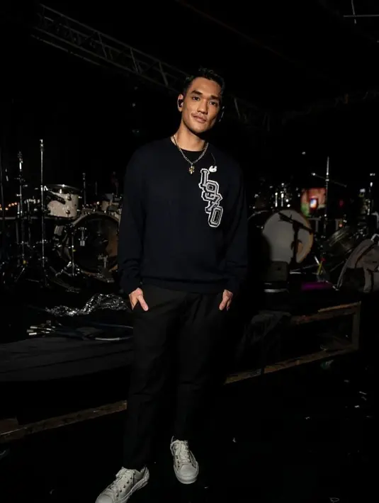 Lagi, pesona Afgan dalam balutan outfit kasual. Ia mengenakan atasan kaus lengan panjang hitam bermotif tulisan, dipadunya dengan celana panjang hitam. [Foto: Instagram/afganisme.official]