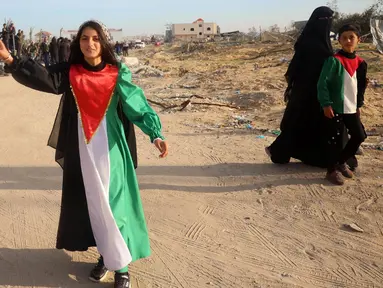 Seorang perempuan muda mengenakan gaun dengan warna bendera Palestina saat orang-orang kembali ke Rafah, Jalur Gaza selatan pada 19 Januari 2025. (Eyad BABA/AFP)