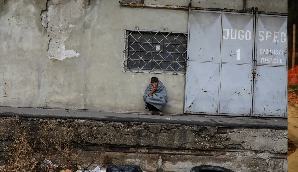 Seorang imigran merokok di depan sebuah gudang tak terpakai yang dijadikan tempat tinggal di Belgrade, Serbia, 10 November 2016. Menurut badan pengungsi PBB, sekitar 6.400 imigran saat ini terdaftar di Serbia. (REUTERS/Marko Djurica)