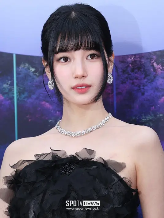 Rambutnya yang panjang dan indah diikat menjadi sanggul dengan poni membingkai wajahnya dengan lembut. [Foto: Twitter/suzycontents].