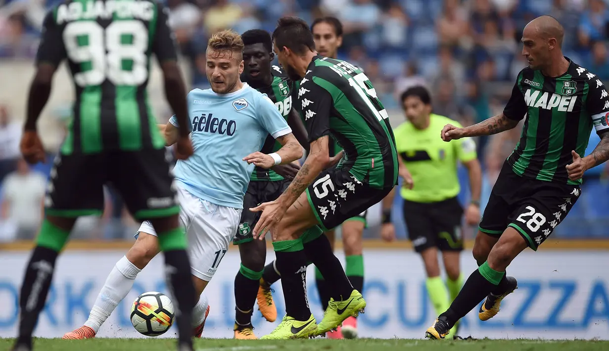 Aksi pemain Lazio, Ciro Immobile (tengah) melewati adangan para pemain Sassuolo pada lanjutan Serie A di Olympic Stadium, Roma, (1/10/2017). Lazio menang telak 6-1. (AFP/Filippo Monteforte)