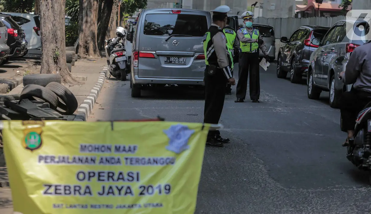 Polisi lalu lintas menggelar Operasi Zebra 2019 di Jalan Boulevard Gading Raya, Jakarta, Kamis (24/10/2019). Operasi selama dua pekan hingga 5 November mendatang tersebut untuk meningkatkan kepatuhan dan kedisiplinan pengendara kendaraan bermotor dalam berlalu lintas. (Liputan6.com/Faizal Fanani)