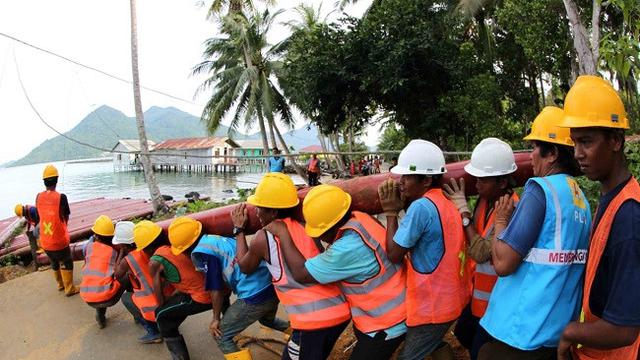 Minimnya infrastruktur membuat karyawan PLN harus memikul tiang-tiang listrik seberat ratusan kilogram (kg) untuk bisa menerangi wilayah di Natuna, (Liputan6.com/Nurseffi Dwi Wahyuni)