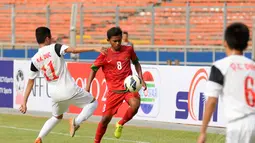 Gelandang timnas U-16 Indonesia, Amirulloh Ruslan (tengah) mencoba lolos dari kawalan Bui Anh Duc (Vietnam - kiri) saat berlaga di Stadion GBK Jakarta, (3/12). Timnas U-16 Indonesia unggul 3-2 atas Timnas U-16 Vietnam. (Liputan6.com/Helmi Fithriansya)