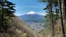 Gunung Fuji terlihat dari pinggiran kota Fujiyoshida, prefektur Yamanashi, Jepang, pada Kamis (22/4/021). Pada tahun 2014, Gunung Fuji terpilih sebagai UNESCO World Culture Heritage Site (Situs Warisan Budaya Dunia). (Behrouz MEHRI / AFP)