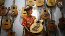 I Wayan Tuges melihat gitar yang telah diukirnya di workshop pembuatan gitar berlabel Blueberry di Jalan Baruna No. 5 Guwang, Sukowati, Bali, Senin (15/10). Gitar-gitar produksinya itu dibanderol seharga puluhan juta rupiah. (Liputan6.com/Angga Yuniar)