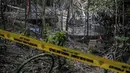 Sebuah garis kepolisian telah dipasang di lokasi base camp penyelundupan manusia di Bukit Wang Burma dekat perbatasan Malaysia-Thailand, (26/5/2015). 139 kuburan massal yang berisi kerangka orang ditemukan.  (AFP PHOTO/MOHD RASFAN)