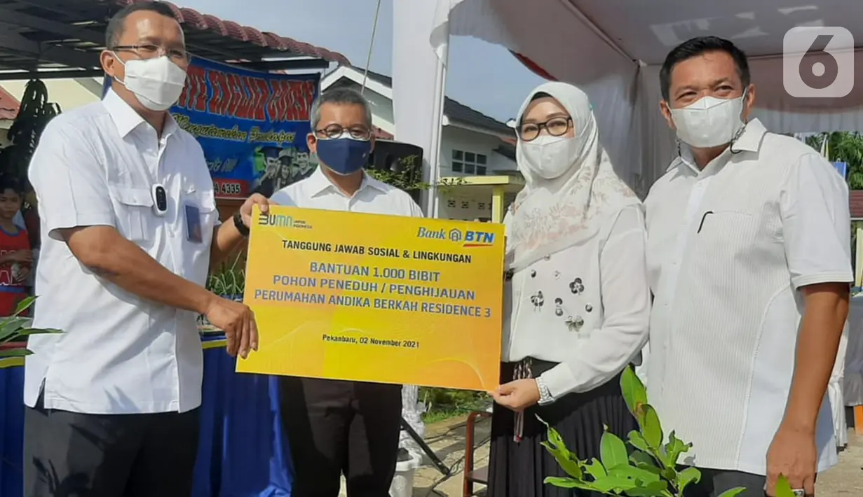 Direktur Utama Bank BTN Haru Koesmahargyo (kiri) disaksikan Wakil Menteri Keuangan Suahasil Nazara (kedua kanan) memberikan bantuan 1.000 bibit pohon peneduh untuk meningkatkan penghijauan di kawasan perumahan subsidi di Pekanbaru, Selasa (2/11/2021). (Liputan6.com/HO/BTN)