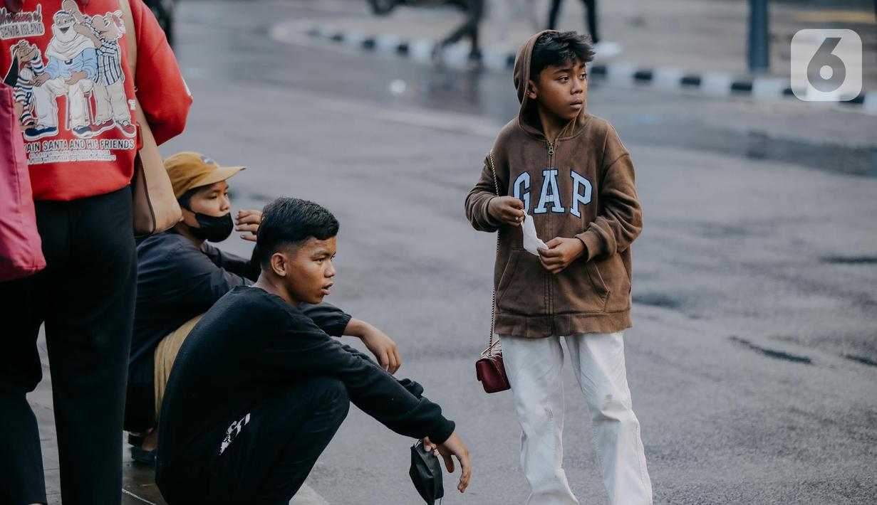 Para remaja dari berbagai daerah di pinggiran Jakarta berkumpul di Taman Sudirman, Jakarta, Rabu (6/7/2022). Tempat ini viral karena jadi ajang adu fashion anak Citayam, Bekasi hingga Bojong Gede. Mereka mengenakan kemeja flanel oversize, celana model 90-an seperti boot cut atau cutbray, sneakers klasik, dan topi. (Liputan6.com/Faizal Fanani)