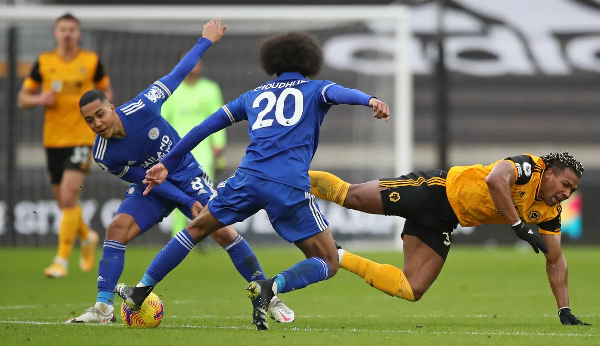 Gelandang Wolverhampton, Adama Traore (kanan) terjatuh dihadang dua gelandang Leicester, Youri Tielemans (kiri) dan Hamza Choudhury dalam laga lanjutan Liga Inggris 2020/21 pekan ke-23 di Molineux Stadium, Minggu (7/2/2021). Wolverhampton bermain imbang 0-0 dengan Leicester. (AFP/Nick Potts/Pool)