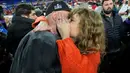 Setelah berhasil membelah kerumunan, Taylor akhirnya mendapati sang kekasih. Mereka pun saling berpelukan dan berciuman di depan banyak orang. (AP Photo/Julio Cortez)