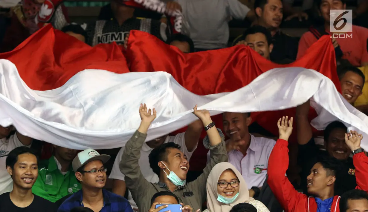 Suporter membentangkan bendera saat menyaksikan laga Indonesia melawan Qatar di Kejuaraan Voli Asia 2017 di GOR Tri Dharma, Gresik, Rabu (26/7). Indonesia unggul 3-2 (24-26, 14-25, 25-20, 25-21, 15-11). (Liputan6.com/Helmi Fithriansyah)