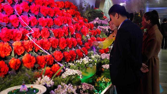 Orang-orang mengunjungi pameran bunga 'Kimjongilia' di Pyongyang, Kamis (14/2). Korea Utara menggelar festival bunga untuk merayakan ulang tahun mendiang mantan pemimpin tertinggi Korea Utara yang juga ayah Kim Jong-un, Kim Jong-il. (AP/Jon Chol Jin)